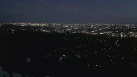 Antena:-Espectacular-Carro-Sobre-El-Cartel-De-Hollywood-En-La-Noche-Con-Las-Luces-De-La-Ciudad-De-Los-Angeles