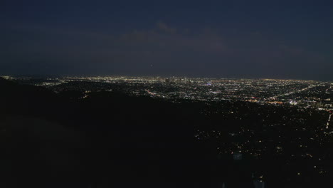 AERIAL:-Spectacular-View-over-Hollywood-Sign-at-Night-with-Los-Angeles-City-Lights