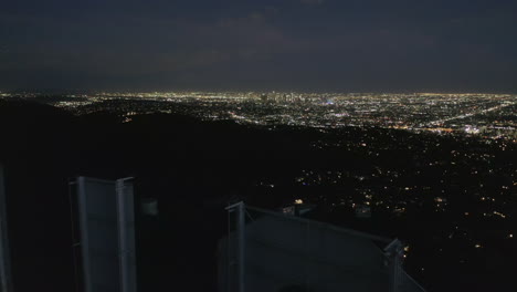 AERIAL:-Spectacular-Flight-over-Letter-O-of-Hollywood-Sign-at-Night-with-Los-Angeles-City-Lights