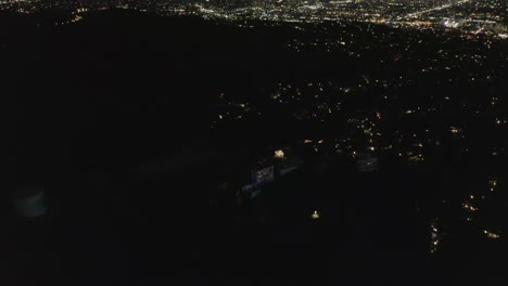 AERIAL:-Slow-Tilt-Move-over-Hollywood-Hills-at-Night-revealing--Los-Angeles-City-Lights