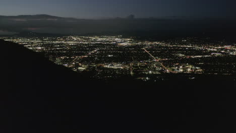 AERIAL:-Flight-over-Hollywood-Hills-at-Night-with-view-on-Valley-,-Burbank-and-City-Lights