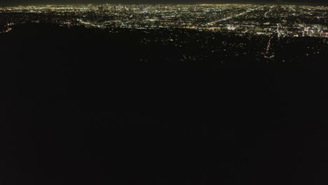 Slow-Tilt-Move-over-Hollywood-Hills-at-Night-revealing--Los-Angeles-City-Lights