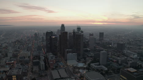 AERIAL:-Breathtaking-view-of-skyscrapers-in-Downtown-Los-Angeles,-California-at-beautiful-Sunset