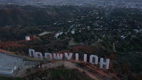 Breathtaking-Tilt-up-over-Hollywood-Sign-Letter-from-back-revealing-Los-Angeles-Cityscape-in-Beautiful-Sunset-Light