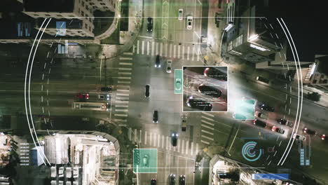 Top-down-ascending-footage-of-traffic-on-road-intersection-in-city-at-night.-Futuristic-visual-effect-tracking-and-providing-data-from-selected-vehicles