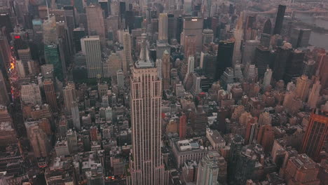 Antenne:-Nahaufnahme-Des-Empire-State-Building-Mit-Midtown-Manhattan,-Times-Square-Im-Hintergrund-Bei-Sonnenaufgang,-Sonnenuntergang