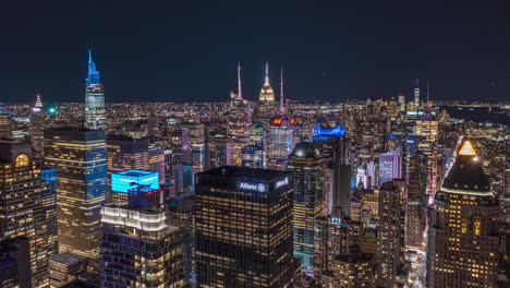 Aerial-night-city-hyperlapse.-Fly-above-illuminated-downtown-skyscrapers.-Glowing-light-from-advertisement-displays-at-Time-Square.-Manhattan,-New-York-City,-USA