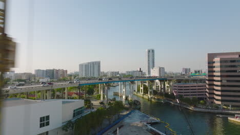 Forwards-fly-around-crane,-revealing-highway-bridge-over-Miami-river.-Heavy-traffic-on-trunk-road.-Miami,-USA