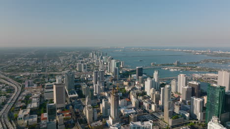 Breath-taking-aerial-panoramic-footage-of-modern-city-borough-along-sea-bay-lit-by-sun-at-golden-hour.-Miami,-USA