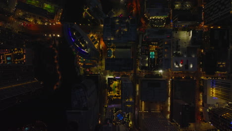Top-down-shot-of-streets-and-blocks-of-high-rise-buildings.-Colourfully-illuminated-night-city-scene.-Miami,-USA