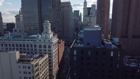 Aerial-footage-of-long-straight-Broadway-street-sandwiched-between-high-rise-downtown-buildings.-Manhattan,-New-York-City,-USA