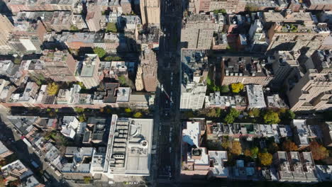 High-angle-view-of-wide-street-leading-between-tall-buildings.-Houses-are-arranged-into-blocks-in-regular-grid.-Manhattan,-New-York-City,-USA