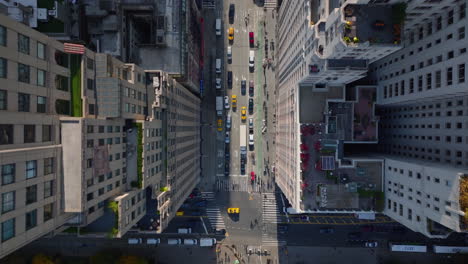 Aerial-birds-eye-overhead-top-down-panning-view-of-cars-moving-on-wide-streets-between-high-rise-buildings-in-city.-Manhattan,-New-York-City,-USA