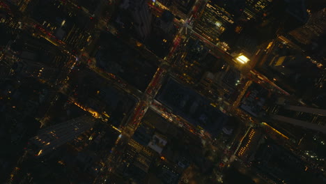 Aerial-birds-eye-overhead-top-down-footage-of-evening-traffic-in-city-centre.-Regularly-arranged-streets-between-blocks-of-high-rise-buildings.-Manhattan,-New-York-City,-USA