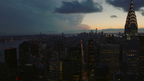 Aerial-panoramic-view-of-cityscape-at-dusk.-Fly-above-city-after-sunset.-High-rise-buildings-and-downtown-skyscrapers.-Manhattan,-New-York-City,-USA