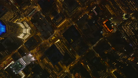 Aerial-birds-eye-overhead-top-down-view-of-illuminated-streets-and-high-rise-apartment-buildings-in-night-city.-Manhattan,-New-York-City,-USA