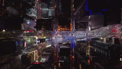 Aerial-birds-eye-overhead-top-down-ascending-view-of-highly-illuminated-Times-Square.-Cars-driving-on-street-between-high-rise-buildings-in-night-city.-Manhattan,-New-York-City,-USA