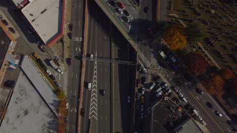 Aerial-birds-eye-overhead-top-down-view-of-cars-driving-on-multilane-expressway-in-city.-Road-bridge-over-highway.-Queens,-New-York-City,-USA