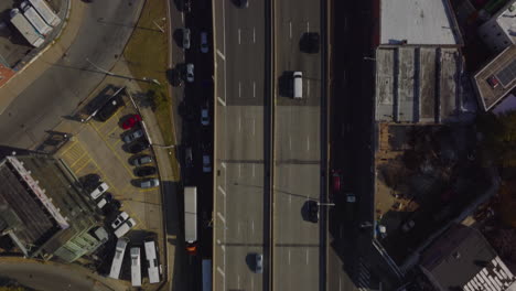 Aerial-birds-eye-overhead-top-down-panning-view-of-traffic-on-multilane-highway-leading-trough-town-borough.-Cars-driving-on-elevated-road.-Queens,-New-York-City,-USA