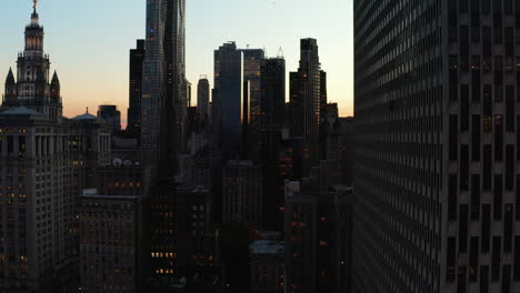 Aufsteigende-Aufnahmen-Von-Hohen-Wolkenkratzern-In-Der-Innenstadt-In-Der-Abenddämmerung.-Hochhaus-Bürogebäude-Silhouetten-Gegen-Farbenfrohen-Sonnenuntergang-Himmel.-Manhattan,-New-York-City,-Vereinigte-Staaten