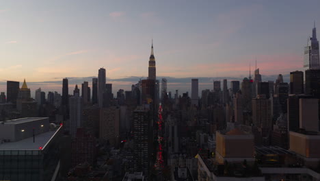 Panoramablick-Auf-Hochhäuser-In-Midtown.-Beleuchtete-Spitze-Des-Empire-State-Building-Gegen-Den-Himmel-In-Der-Abenddämmerung.-Manhattan,-New-York-City,-Vereinigte-Staaten