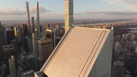 Ascending-tilt-down-view-of-oblique-roof-of-business-skyscraper-in-city-at-dusk.-Manhattan,-New-York-City,-USA