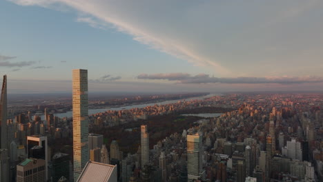 Aerial-panoramic-footage-of-cityscape-at-dusk.-Descending-shot-of-high-rise-buildings-around-Central-Park.-Manhattan,-New-York-City,-USA