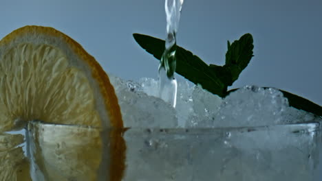 Nahaufnahme-Wasser-Gießt-Limonade-Trinken.-Soda-Füllung-Eisgekühltes-Zitrus-Minz-Getränk