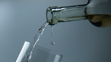 White-wine-flowing-glass-closeup.-Beautiful-liquid-droplet-falling-into-goblet