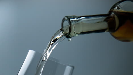 Bottle-pouring-white-wine-into-goblet-closeup.-Grape-liquid-flowing-into-glass