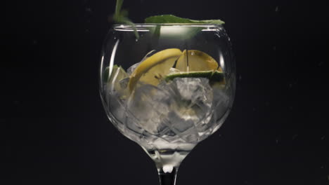 Lemons-mint-falls-ice-cubes-wineglass-closeup.