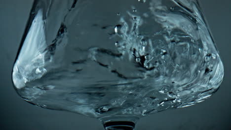 Closeup-water-filling-glass-at-light-background.-Pure-mineral-liquid-pouring