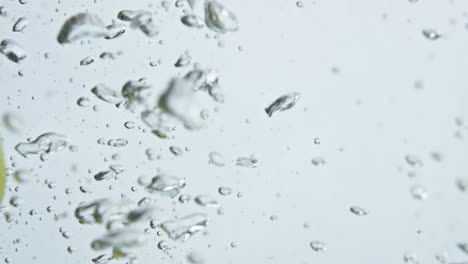 Tropical-limes-splash-water-in-light-background-closeup.-Beautiful-cooking-shot