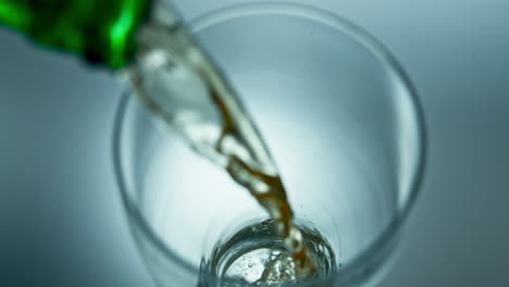 Beer-stream-pouring-glass-from-bottle-closeup.-Unfiltered-lager-filling-goblet