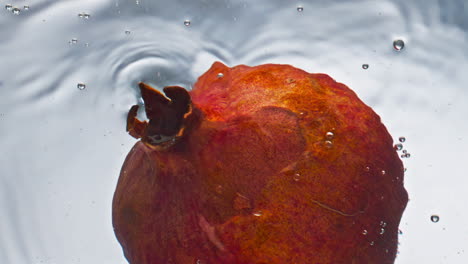 Primer-Plano-De-Granada-Que-Fluye-Agua-En-Un-Fondo-Claro.-Fruta-Tropical-Dulce