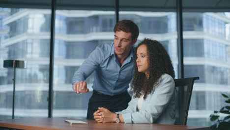 Business-colleagues-discussing-metaverse-display.-Professionals-couple-talking