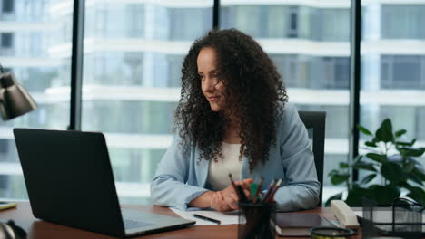 Woman-starting-video-conference-sitting-office-desk-closeup.-Girl-working-laptop