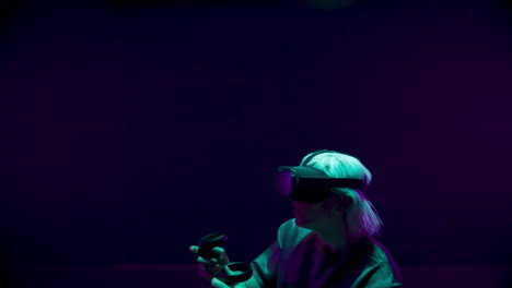 Teenager-playing-virtual-reality-in-neon-light-closeup.-Cyber-gamer-enjoy-online