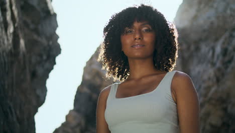 African-american-girl-vertical-portrait-in-front-sunshine.-Woman-standing-beach.