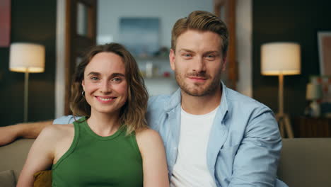 Smiling-couple-watching-comedy-sitting-couch-zoom-on.-Laughing-family-together