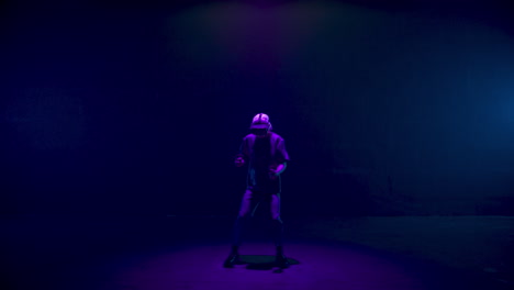 Vr-man-gesturing-game-in-neon-lights-room.-Blonde-player-use-headset-controllers