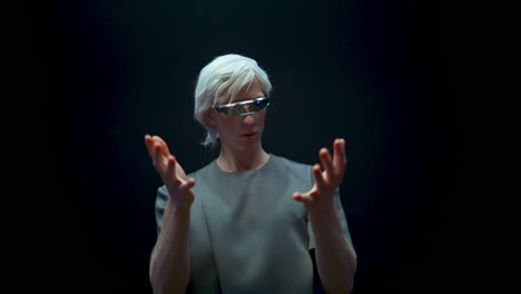 Closeup-vr-player-immersing-augmented-reality-in-futuristic-glasses-dark-room.