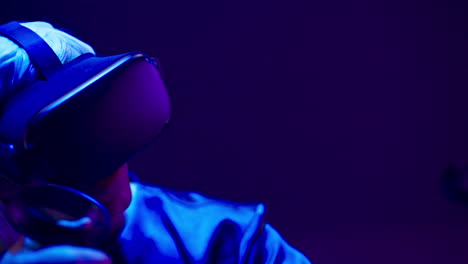 Typ-Mit-VR-Headset-Spielt-Im-Neonlicht.-Mann-Verwendet-Futuristischen-Technologiehelm
