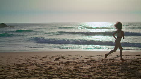 Energiegeladene-Frau-Joggt-Am-Strand-Bei-Sonnenaufgang,-Vertikale-Aufnahme.-Glückliches-Mädchen-Dreht-Sich-An-Der-Küste