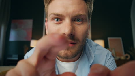 Pov-surprised-man-typing-fingers-screen-at-house.-Wondering-guy-face-closeup