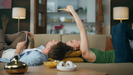 Carefree-spouses-laying-sofa-at-home.-Happy-lady-making-mobile-phone-selfie