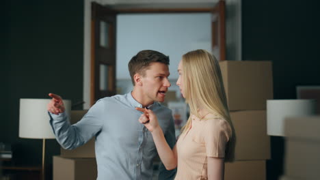 Aggressive-man-scolding-woman-in-home-close-up.-Couple-experiencing-problems.