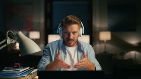 Remote-worker-chatting-computer-dark-apartments-closeup.-Man-talking-gesturing