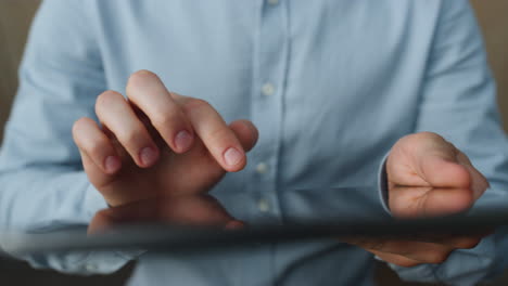 Man-fingers-typing-tablet-closeup.-Unknown-guy-texting-message-on-tab-computer.