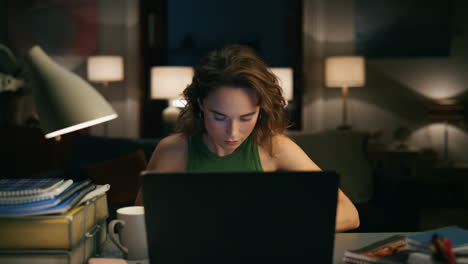 Serious-woman-making-notes-evening-house-closeup.-Involved-girl-watching-laptop